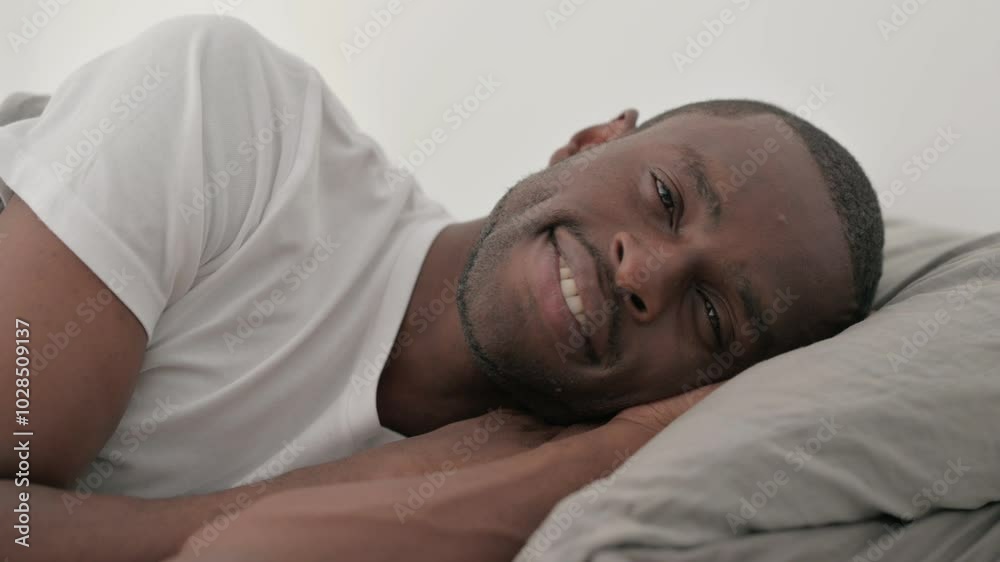 Close up of Smiling African Man Lying on Side in Bed Close up of Smiling African Man Lying on Side in Bed