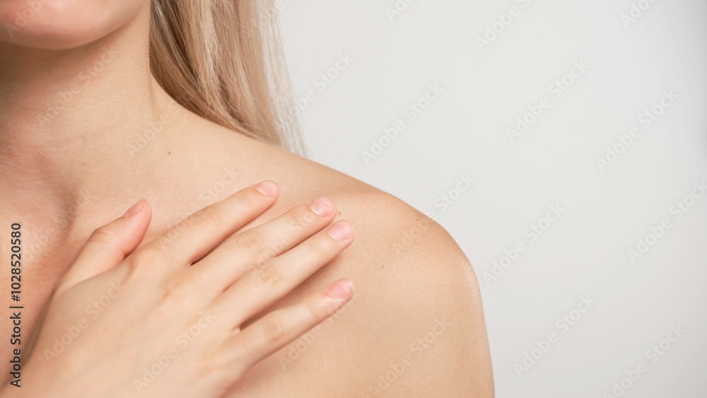 Young blonde woman posing at camera, touching shoulders looking naturally, isolated on white studio background close up shot. Beauty skin care concept Young blonde woman posing at camera, touching shoulders looking naturally, isolated on white studio background close up shot. Beauty skin care concept
