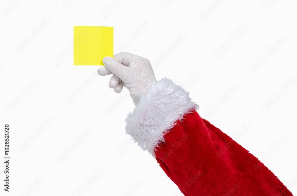 Shot of an Santa Claus hand holding a yellow notepaper on a white isolated background Shot of an Santa Claus hand holding a yellow notepaper on a white isolated background