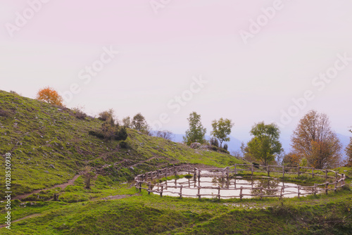 Watering hole with fence, in the Italian mountains. Morterone, Lombardy, Italy photo