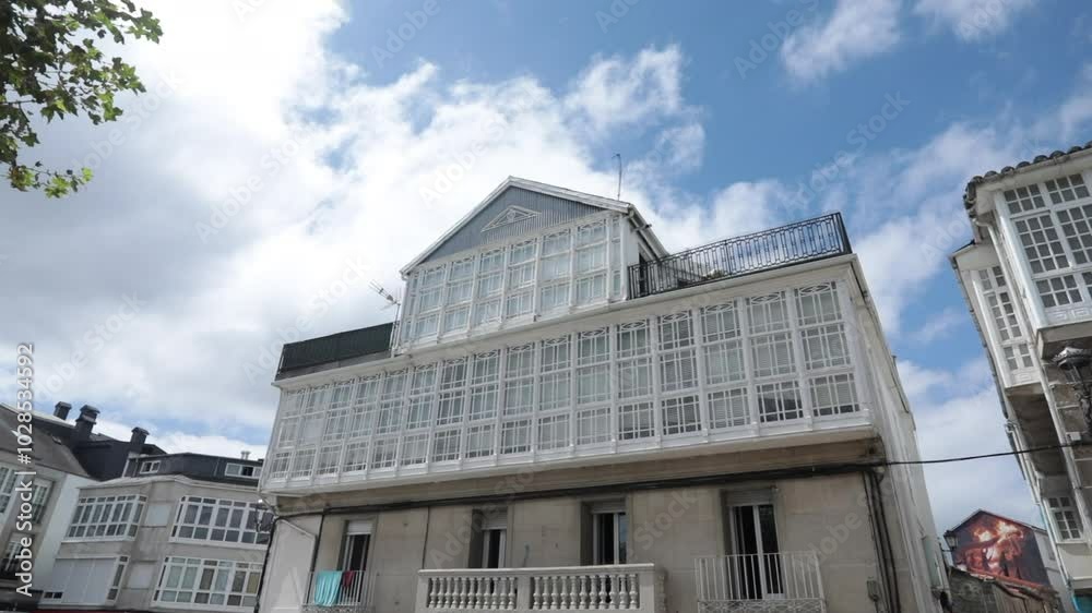 Traditional Spanish houses with glass-enclosed balconies under a bright blue sky Traditional Spanish houses with glass-enclosed balconies under a bright blue sky