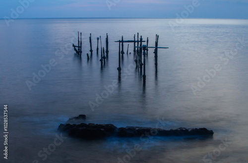 The twilight atmosphere before sunset at Ampenan Beach, Mataram, West Nusa Tenggara, Indonesia. A beautiful view of blue shades with sea water frozen using slow speed techniques.