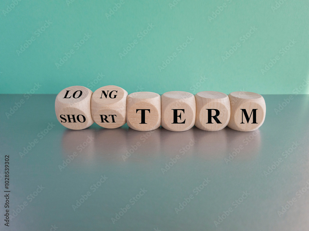 Turned wooden cubes and changes the expression SHORT TERM to LONG TERM or vice versa. Beautiful blue background. Business concept.
