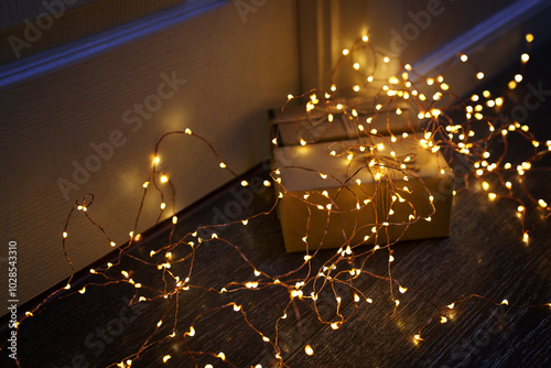 Christmas gifts wrapped and lit with warm fairy lights photo