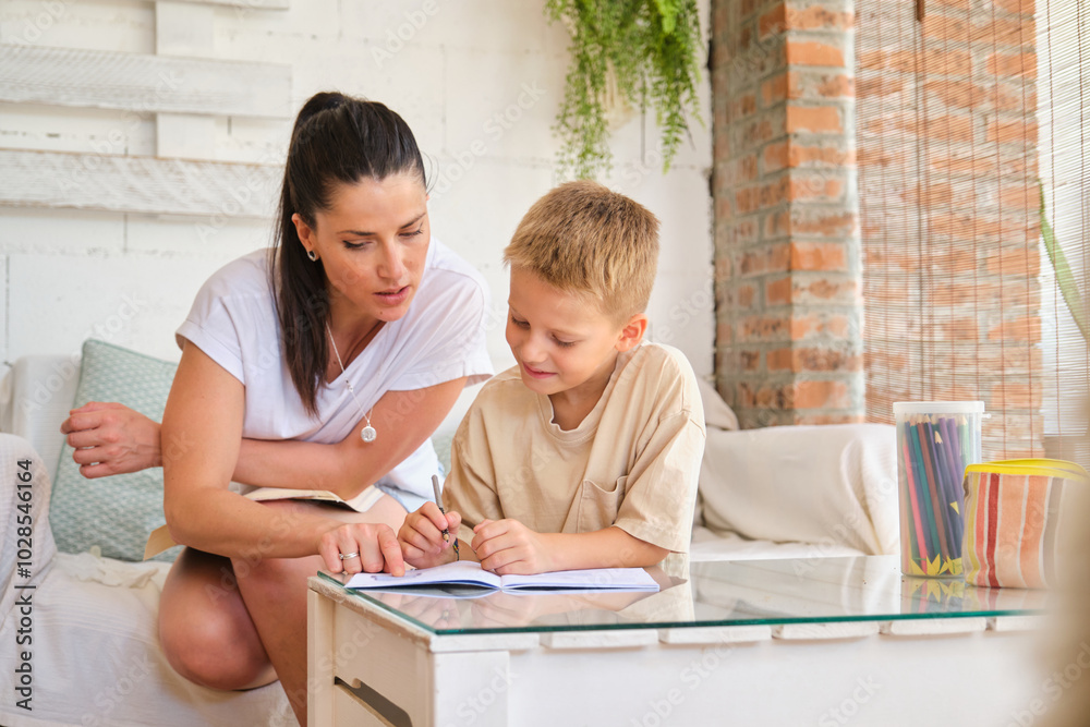 Mother helping son with homework in cozy home setting Mother helping son with homework in cozy home setting