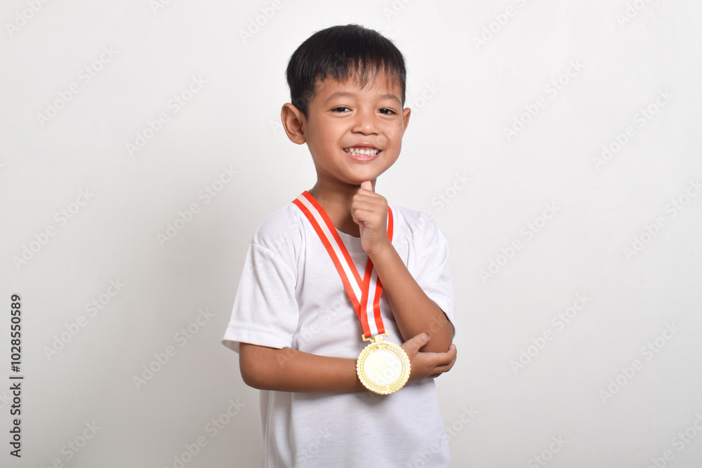 Little Asian boy smiling with a gold medal on his chest isolated on a white background Little Asian boy smiling with a gold medal on his chest isolated on a white background