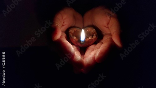 Quadro em tela Hands Holding a Lit Clay Lamp in the Dark