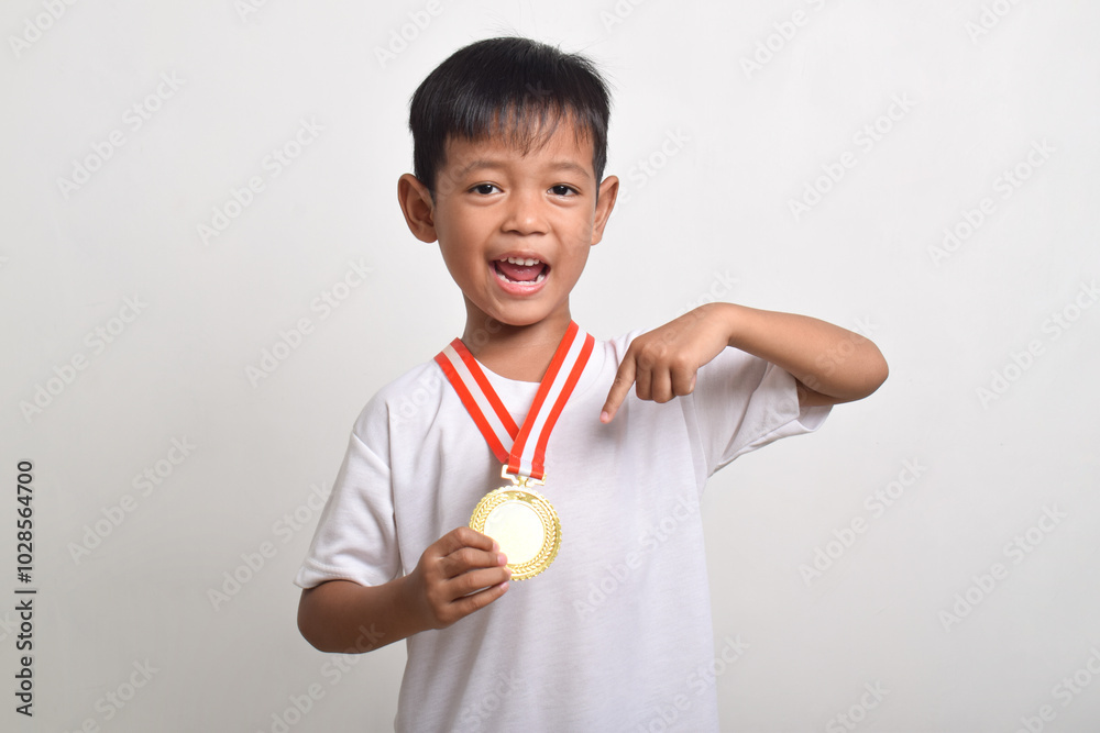 Little asian boy showing his gold medal. Smiling child celebrating his success, isolated on a white background Little asian boy showing his gold medal. Smiling child celebrating his success, isolated on a white background