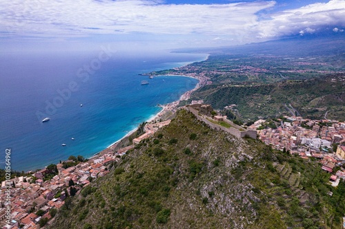 Aerial view of coastal town and historic hilltop castle.