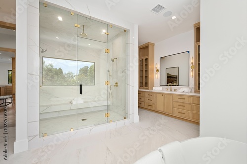 Modern bathroom with glass shower and wooden cabinets.