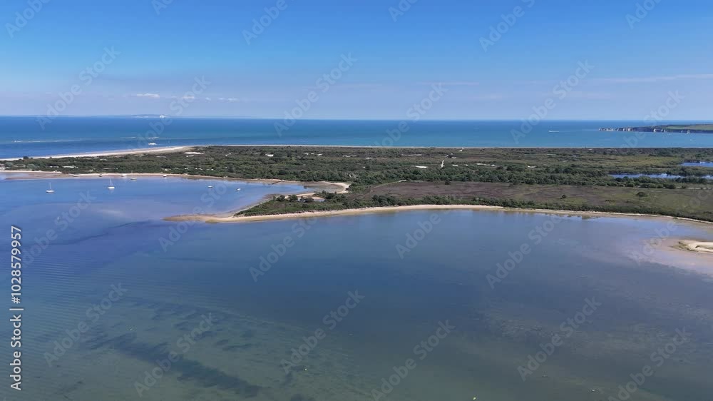 Poole harbour. Beautiful golden beaches of Isle of Purbeck with clear calm water. Drone flight towards Studland Bay with Old Harry Rocks in the distance on sunny day Poole harbour. Beautiful golden beaches of Isle of Purbeck with clear calm water. Drone flight towards Studland Bay with Old Harry Rocks in the distance on sunny day