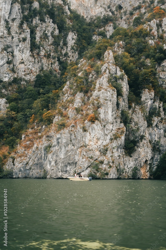 Boat on a lake surrounded by rocky cliffs and greenery. Boat on a lake surrounded by rocky cliffs and greenery.