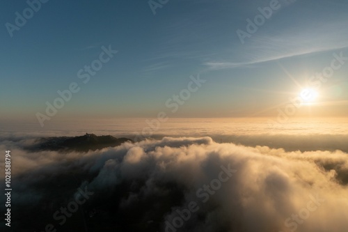 Sunrise over mountain range with clouds and clear sky.