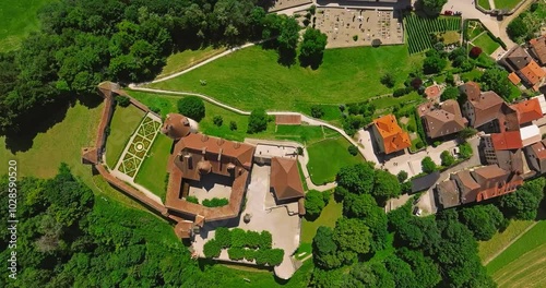 Medieval Swiss castle aerial view in summer. A drone flies through a green valley in the Swiss mountains. Famous Gruyere castle in Switzerland also called Schloss Greyerz, aerial shot by drone photo