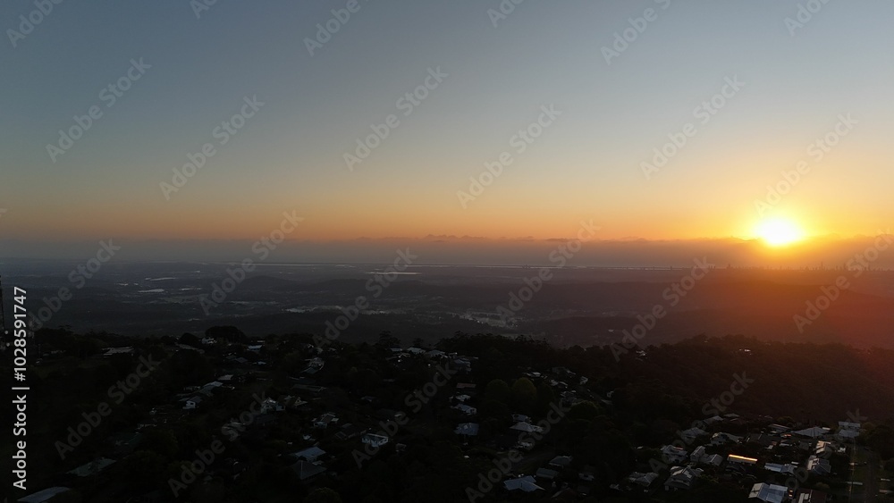 Obraz premium Sunset over hills and city skyline