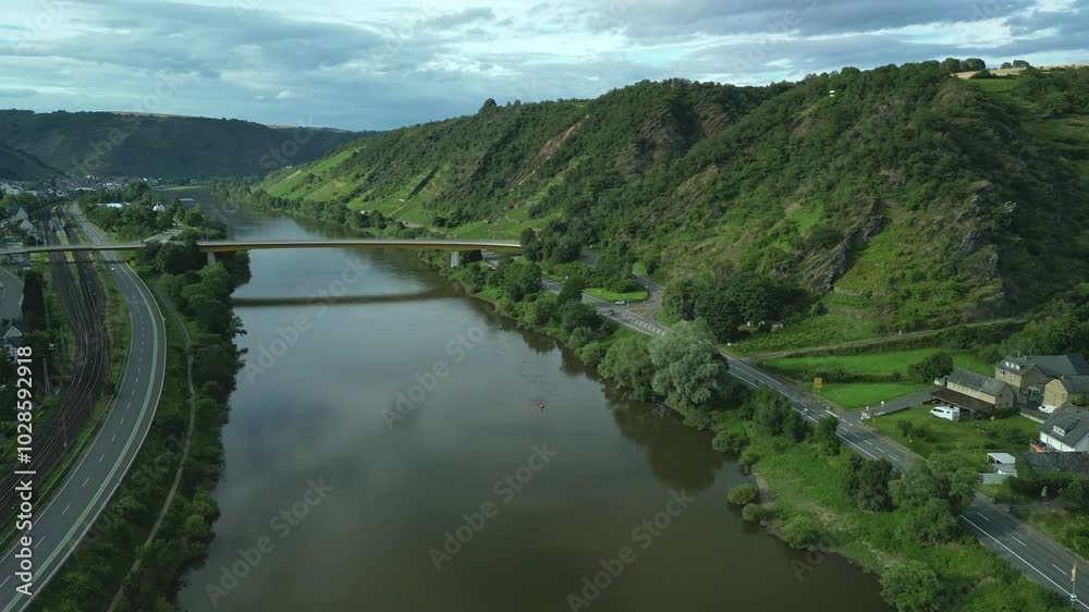 Aerial view of Moselle Gold Bridge on Moselle river surrounded by roads, houses and green mountains Aerial view of Moselle Gold Bridge on Moselle river surrounded by roads, houses and green mountains