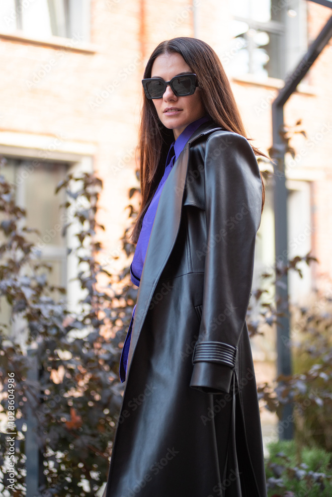 Fototapeta premium Beautiful woman wearing long leather coat, walking on the street