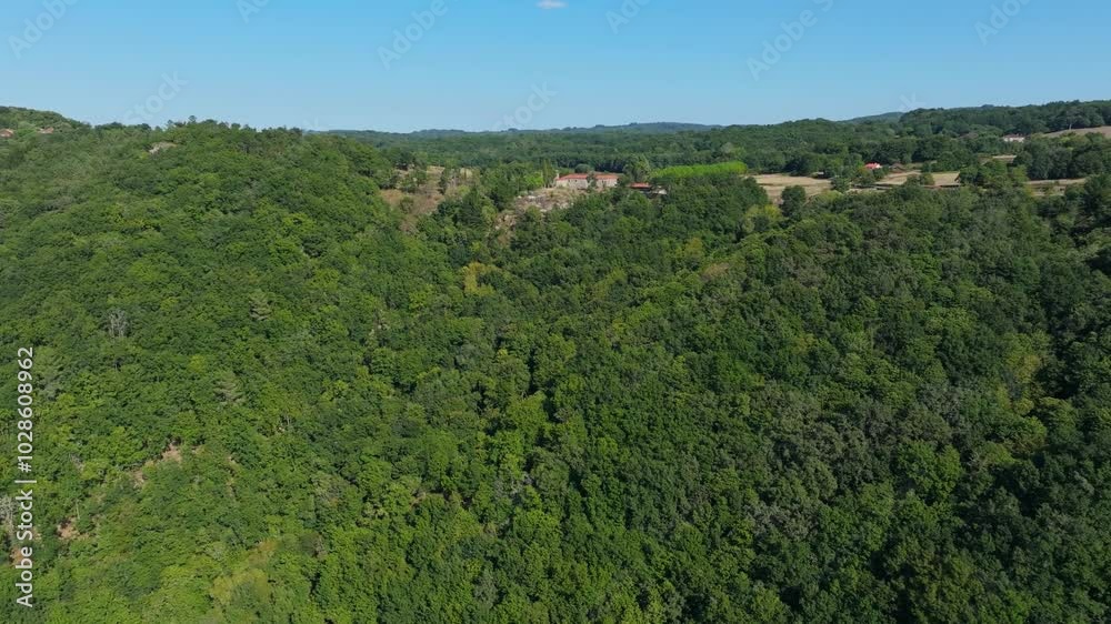 Drone flying above forested mountain towards farmhouse and fields on a sunny day in Spain Drone flying above forested mountain towards farmhouse and fields on a sunny day in Spain