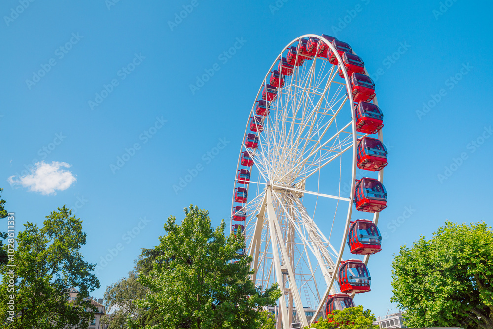 Giant Ferris Wheel Against Blue Sky and Lush Greenery Giant Ferris Wheel Against Blue Sky and Lush Greenery