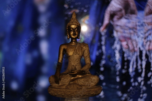 Earth Touching Buddha Statue with colorful backdrop with copy space, Bhumisparsha Buddha, Buddha in a seated meditation pose with his right hand touching the earth. 