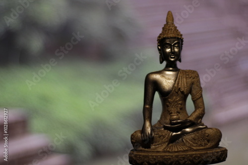 Earth Touching Buddha Statue with colorful backdrop with copy space, Bhumisparsha Buddha, Buddha in a seated meditation pose with his right hand touching the earth.  photo