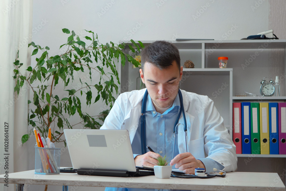 A young doctor receives patients at his workplace. A young doctor receives patients at his workplace.