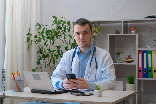 A young doctor receives patients at his workplace.