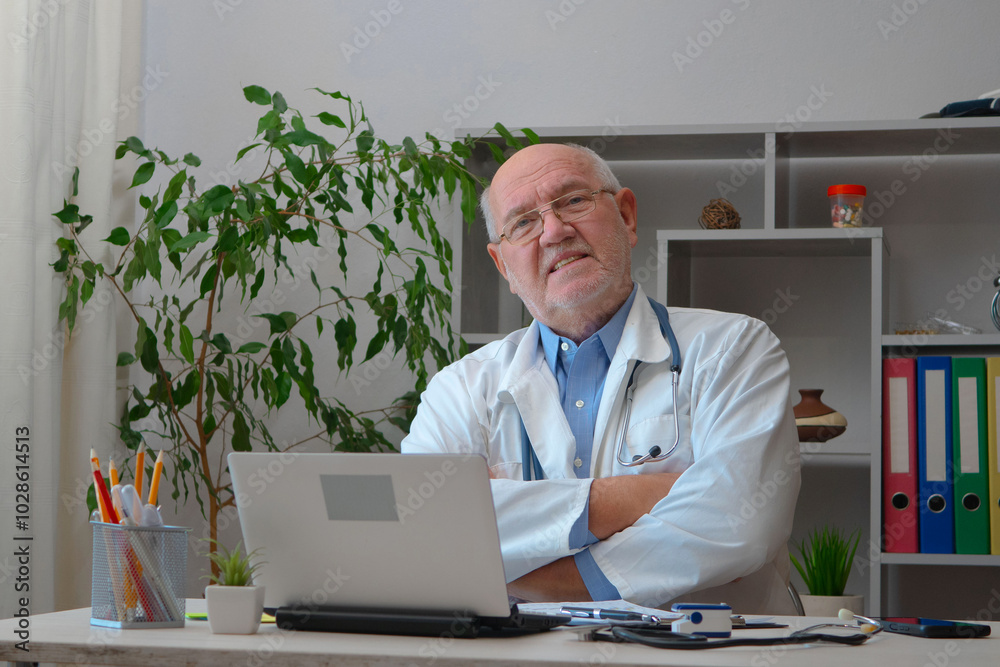 An elderly doctor receives patients at his workplace. An elderly doctor receives patients at his workplace.