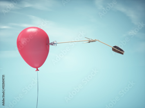 Broken arrow aiming at a red balloon, symbolizing focus