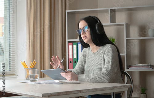 A young beautiful girl works in an office, makes an accounting report.