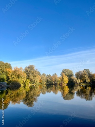 autumn trees reflection on the lake surface, blue lake reflection, golden autumn, lake in the park with quiet water as a mirror 