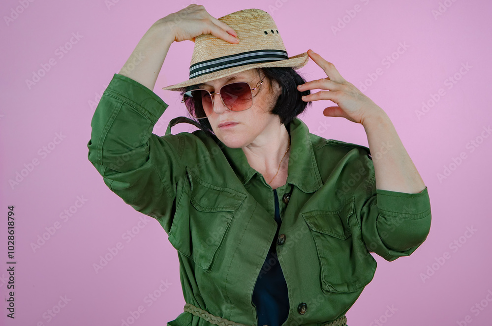Mature woman in a straw hat. Pink background. Mature woman in a straw hat. Pink background.