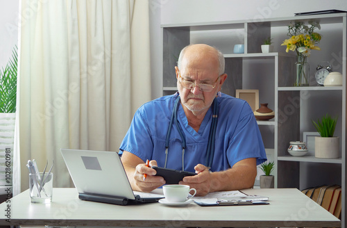 An elderly man, a doctor, in his office, at a table.