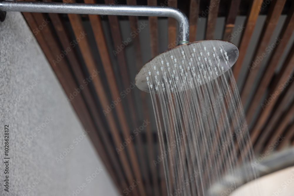 A shower head is spraying water in a shower A shower head is spraying water in a shower