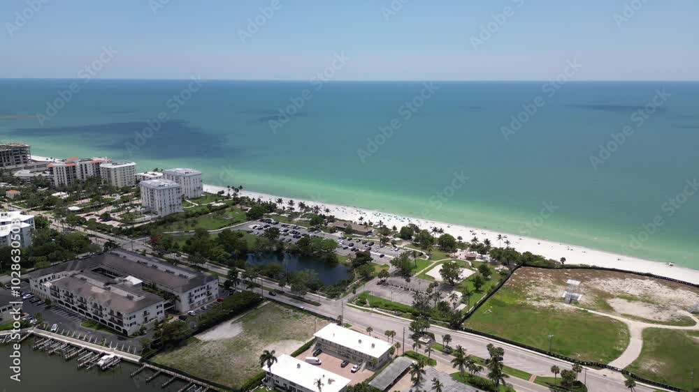 Drone over Lowdermilk Beach with white sand, blue ocean and coastal buildings in Naples, Florida Drone over Lowdermilk Beach with white sand, blue ocean and coastal buildings in Naples, Florida