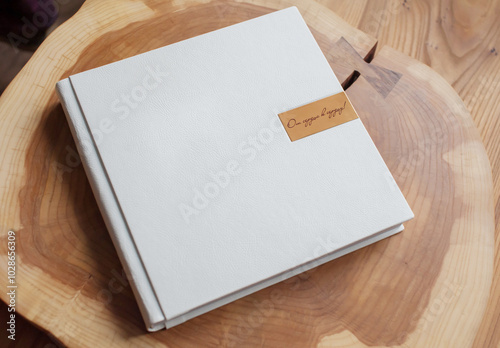 White photo album in leather cover on wooden table photo