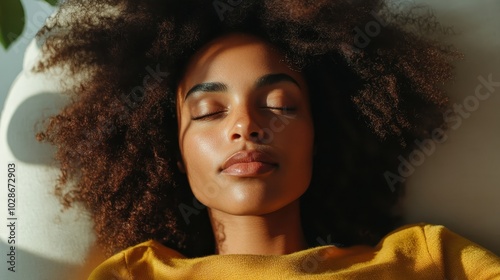 A woman is reclining with closed eyes in a warm, golden afternoon light, reflecting peace, calm, and relaxation. The soft texture of her clothing adds warmth. photo