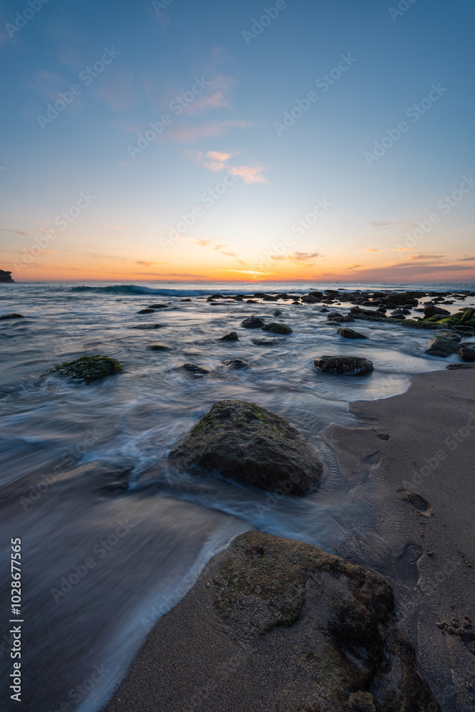 Water flowing around rocks on the beach shore. Water flowing around rocks on the beach shore.