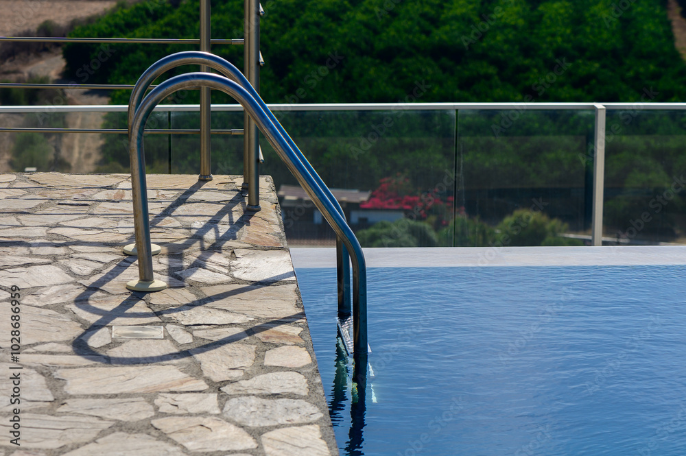 Steps into the pool with handrails in water reflex sun. For tourists. Steps into the pool with handrails in water reflex sun. For tourists.