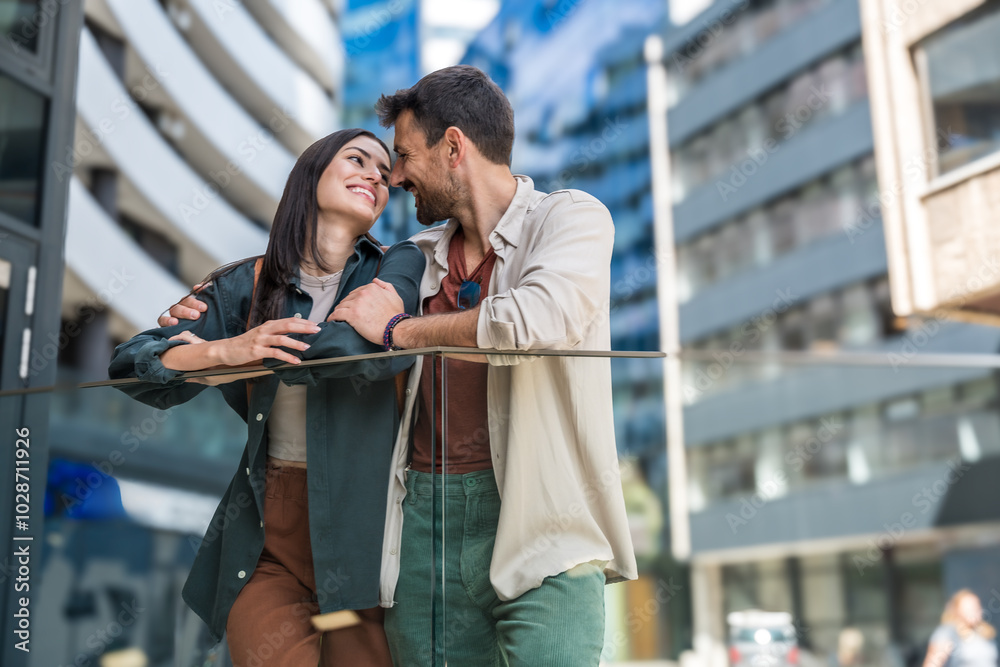 Young happy couple in love waiting for their real estate agent to give them the tour of their new apartment to buy or for rent. Man and woman wait outside residential building of their new home. Young happy couple in love waiting for their real estate agent to give them the tour of their new apartment to buy or for rent. Man and woman wait outside residential building of their new home.