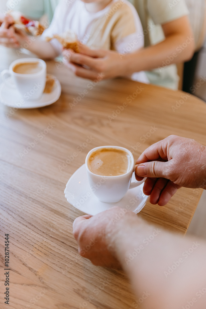 Hands serving fresh coffee at breakfast with a child enjoying croissants, a cozy start to the day Hands serving fresh coffee at breakfast with a child enjoying croissants, a cozy start to the day