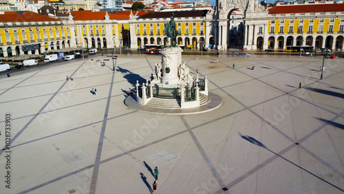 Uma imagem icónica do Terreiro do Paço (também conhecido como Praça do Comércio), situada na Baixa Pombalina, em Lisboa. A ampla praça está rodeada por majestosos edifícios de cor amarela com arcadas  photo