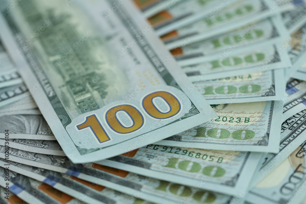 Many hundred dollar bills new banknotes in big pile under the natural light Many hundred dollar bills new banknotes in big pile under the natural light