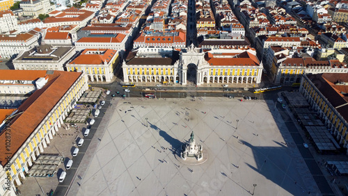 Uma imagem icónica do Terreiro do Paço (também conhecido como Praça do Comércio), situada na Baixa Pombalina, em Lisboa. A ampla praça está rodeada por majestosos edifícios de cor amarela com arcadas  photo