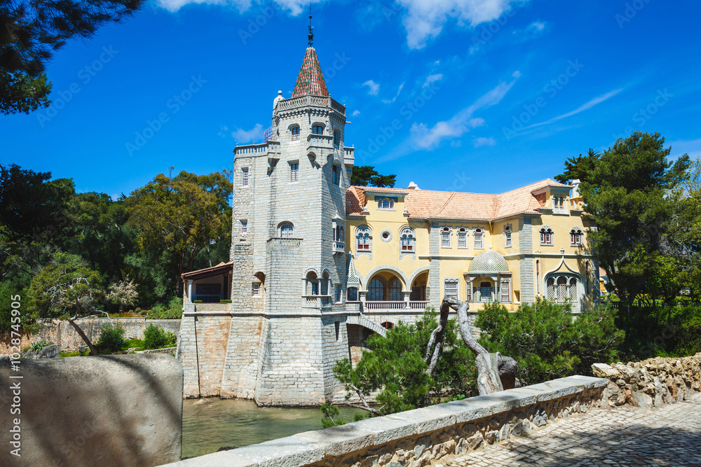 Fototapeta premium A beautifully preserved, castle-like building with a tall stone tower, arched windows, and intricate details, nestled among lush greenery