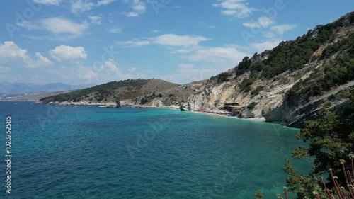 A stunning aerial view of Kalami Beach reveals turquoise waters, golden sandy shores, and lush green hills, creating a picturesque coastal paradise from above. photo