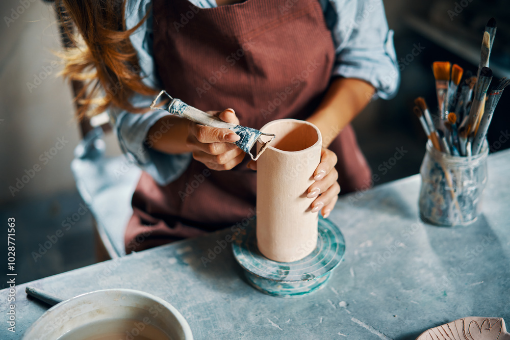 Female artist sculpts crafts with ceramic clay at her creative workshop