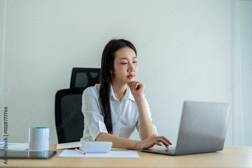 Businesswoman is thinking while working in her office Businesswoman is thinking while working in her office