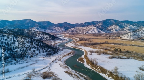 Aerial View of a Winding River Through Snowy Mountains