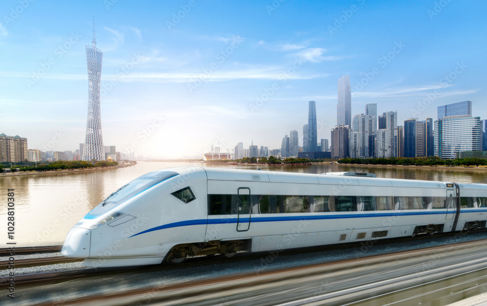 Naklejka premium High-speed rail speeds on Bridges and the modern city skyline of guangzhou, China